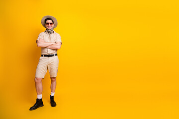 Traveler in safari outfit stands confidently against bright yellow background ready for adventure travel and summer discovery © deagreez