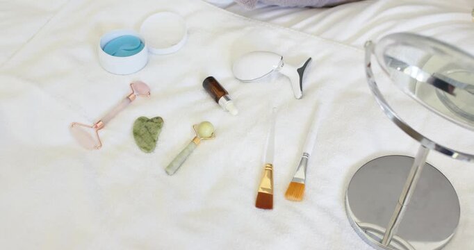 Camera slowly tightening frame, showcasing rollers, gua sha, brushes, mirror, highlighting details