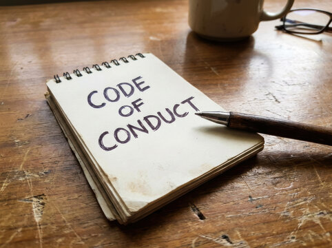 Code conduct rule concern map icons puzzle belief corporation blackboard on wooden desk with notebook pen coffee mug reflect workplace ethic guideline Code of conduct in business concept