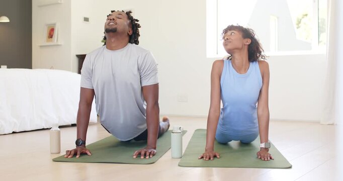 African American couple starting prone lifting chests, pressing palms on mats with bottles for yoga
