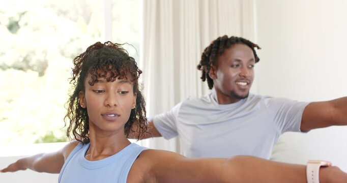 African American couple holding standing pose for fitness, starting arms out, wearing blue tank top