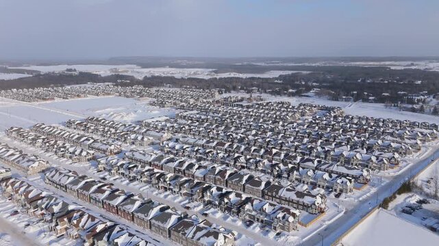 Winter drone footage of a new residential development in Erin, Ontario. Rows of newly built houses in snow reflect ongoing housing construction and the need for expanded residential supply.