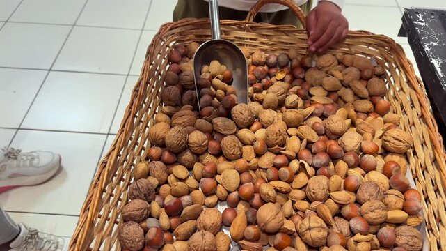 Close-up view of the hands of a young black mother and her son playing with assorted nuts in a basket. slomotion shot.