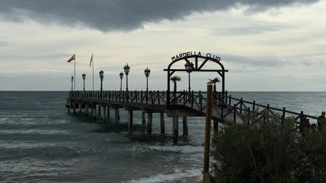 Marbella Club pier with Spanish flag and lampposts