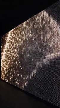 Abstract sparkling light patterns illuminate a large digital pixel screen