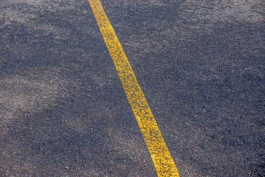 Focus sur une ligne jaune pass&eacute;e, trac&eacute;e sur la route, format paysage