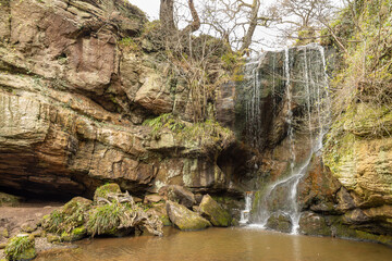 Fototapeta premium Small waterfall over layered rock