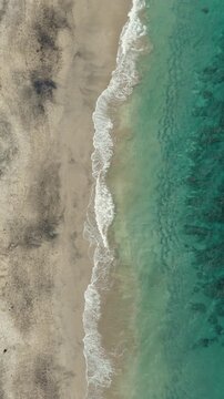 4K drone video flying away from Song Lambung Beach in Nusa Lembongan near Bali in Indonesia. This stunning white sand beach is a popular spot for tourists looking to relax and surf.