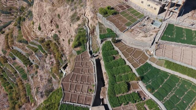 Drone shot of green mountain terraces and ancient falaj irrigation near Nizwa, Oman
