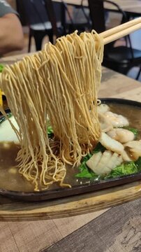 A unique presentation on sizzling noodles in a restaurant.