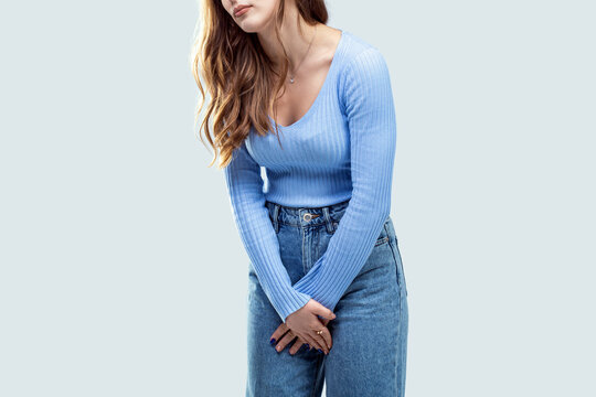 Young woman pressed her hands to the lower abdomen. Medical concept. Woman having painful stomachache. Chronic gastritis. Medical or gynecological problems, healthcare concept