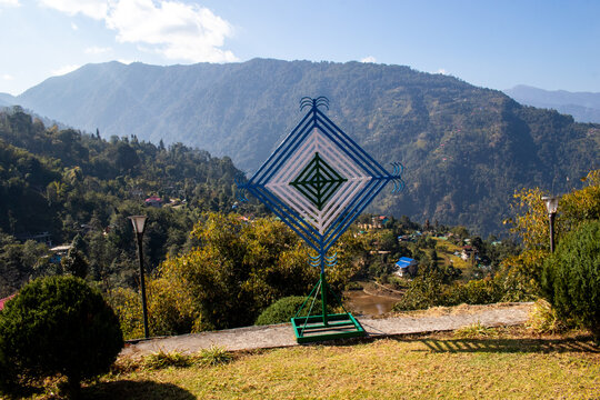 This image shows a Silam Saakmaa, a traditional cultural symbol of the Limbu community in Nepal, often displayed in mountainous outdoor locations. 