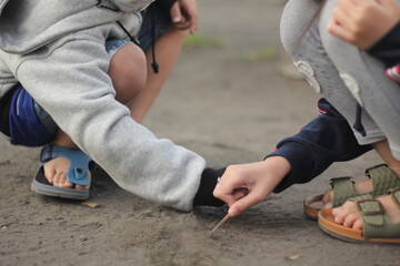brother and sister drawing writing and playing on sandy beach