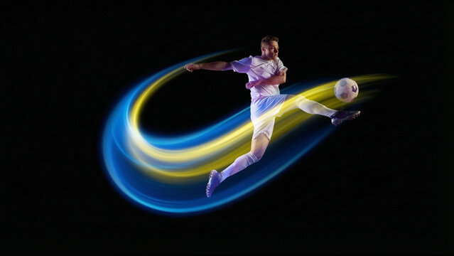 Dynamic poster. Soccer player kicking ball with blue and yellow neon light trails. Concept of sports ads, championship promo visuals, football tournament banners, and fitness motivation campaigns.