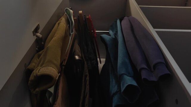 Morning routine showing a person selecting and taking a casual dark shirt from a hanger inside a modern closet, then putting the empty hanger back, preparing to get dressed for the day