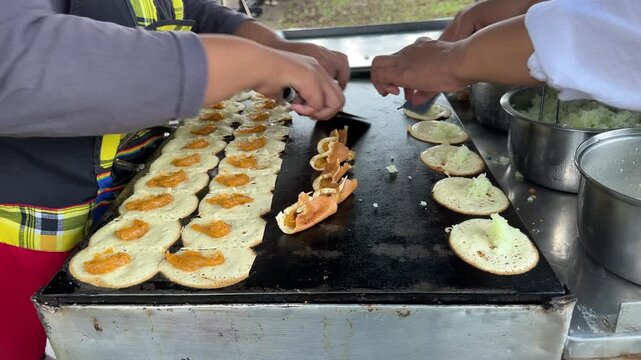 Street vendor preparing delicious food on a griddle