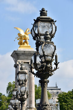 Alexandre III Bridge Detail Portrait with Candelabra Style Streetlights in Foreground and Gilded Pegasus Statue Out of Focus in Background