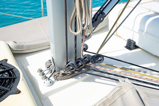 Closeup detail of mast base and rigging on luxury pleasure sailing yacht boat with blue ocean background