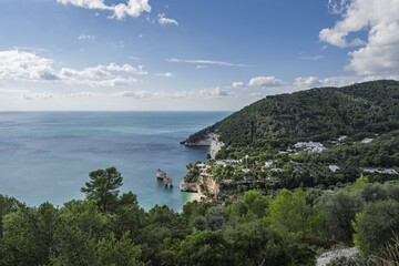 The famous Faraglioni di Baia delle Zagare at Baia dei Mergoli, white limestone cliffs and sea stacks, pristine beach, known as a gem of Gargano, Italy, dramatic Mediterranean coast.