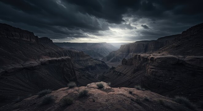 A severe natural panorama featuring sharp, jagged rock formations, deep canyons, and arid wilderness under a dramatic, cloud-filled sky above raw terrain ,shadow ,natural ,stone