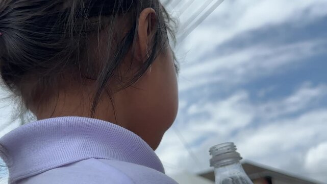 A girl drinking refreshing isotonic drink relieves tropical thirst