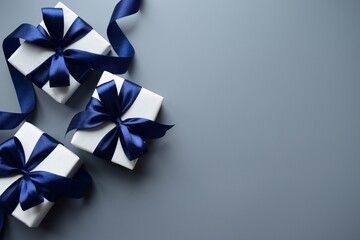 Three gift boxes with blue satin bows on a gray background