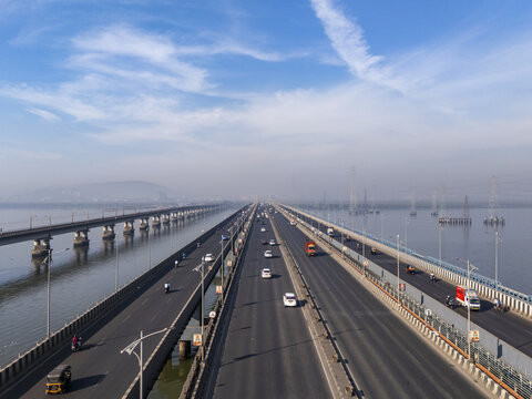 Aerial view of the Vashi Bridge stretching across the Thane Creek under a serene sky, connecting Mumbai to Navi Mumbai, Vashi, Maharashtra, India.