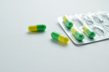 Colored capsules in a foil blister on a light background