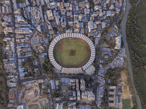 Aerial view of the stadium, surrounded by buildings and a river, stands as a testament to urban life amidst the natural landscape, Thane, Maharashtra, India.