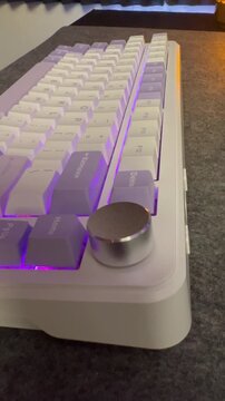 Side view profile of a white mechanical gaming keyboard with purple RGB backlight.