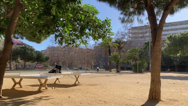 Vista de un parque en la ciudad. Mesas de ping pong. D&iacute;a soleado y con viento