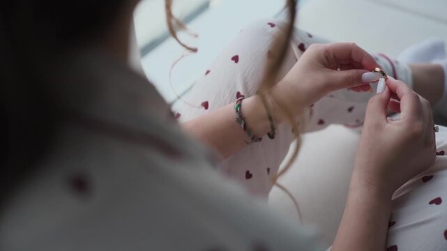 The bride holds a wedding ring in her hands