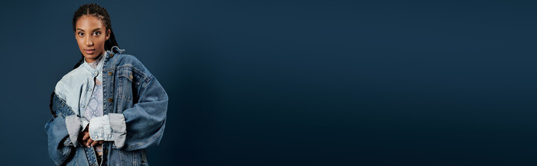 Fashion forward young woman showcasing unique style against a deep blue backdrop