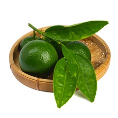 Green citrus fruit with leaves in a woven basket, isolated against a white background