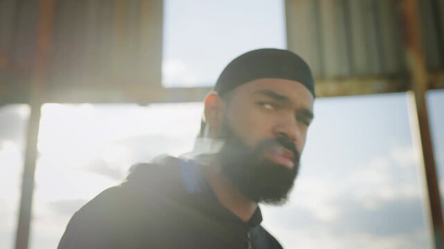 African American man in durag smoking cigarette on rooftop, bad boy image