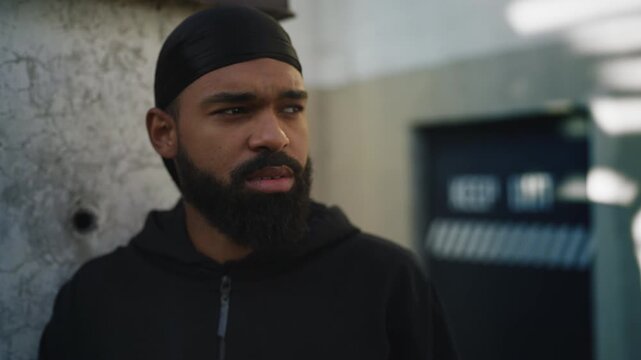 Young African American man in durag smoking cigarette, expressing defiance
