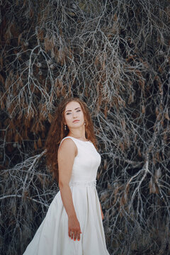 beautiful long-haired bride in white dress with her young man walking in the nature