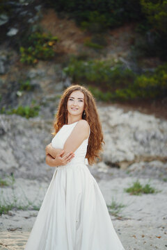 beautiful long-haired bride in white dress with her young man walking in the nature