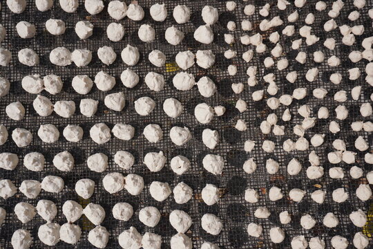 Dried lentil dumplings on dark mesh