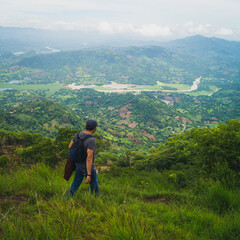 Fototapeta premium Man hiking on Eramon hill in Chalatenango, on a cloudy day