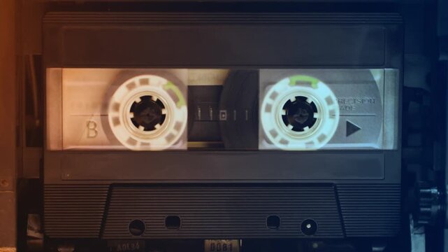 Retro radio tape recorder, audio cassette close-up. Listening to music, old radio boom box player, macro of vintage music listening. 