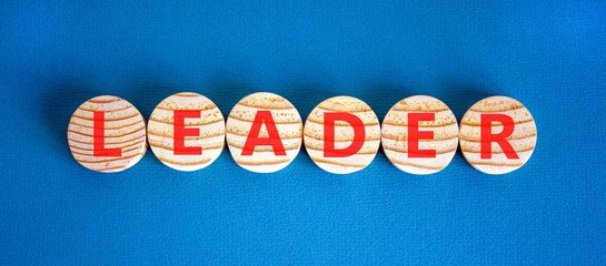 Fototapeta premium Leadership and leader symbol. Concept word Leader on beautiful wooden circles. Beautiful blue background. Business leader and leadership concept. Copy space.