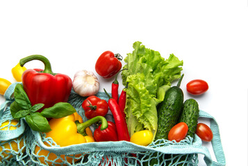 Fresh organic vegetables in reusable shopping bag on white