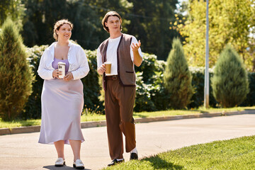 Fototapeta premium Young plus size woman and man walking together in harmony during coffee break 