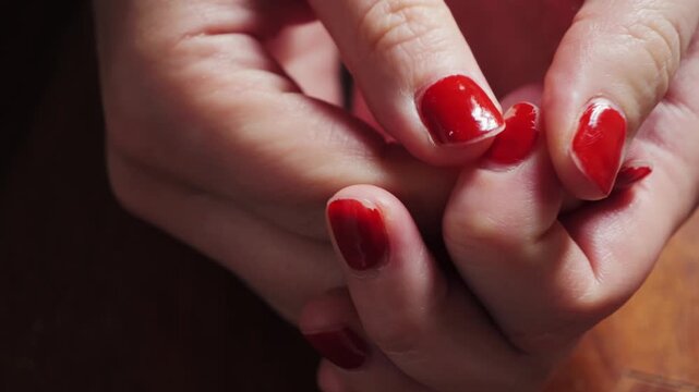 Close-up of fidgeting hands, touching nail polish, and picking at the nail polish is a common behavior often associated with stress, anxiety, and boredom. High quality 4k footage