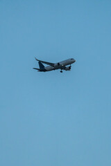 Commercial airplane flying in clear sky minimal composition, Vertical