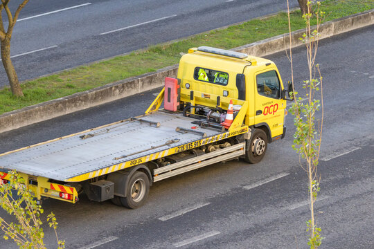 Yellow flatbed tow truck providing roadside assistance service
