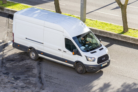 White ford transit cargo van driving on city street