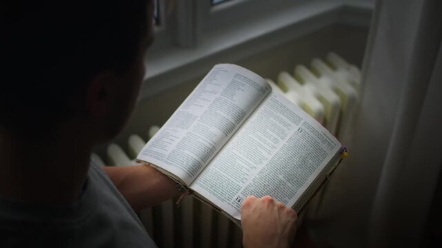man doing bible devotions in morning window light