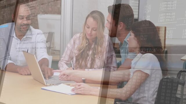 Four colleagues pointing at laptop and jotting notes around table reviewing code with code overlays